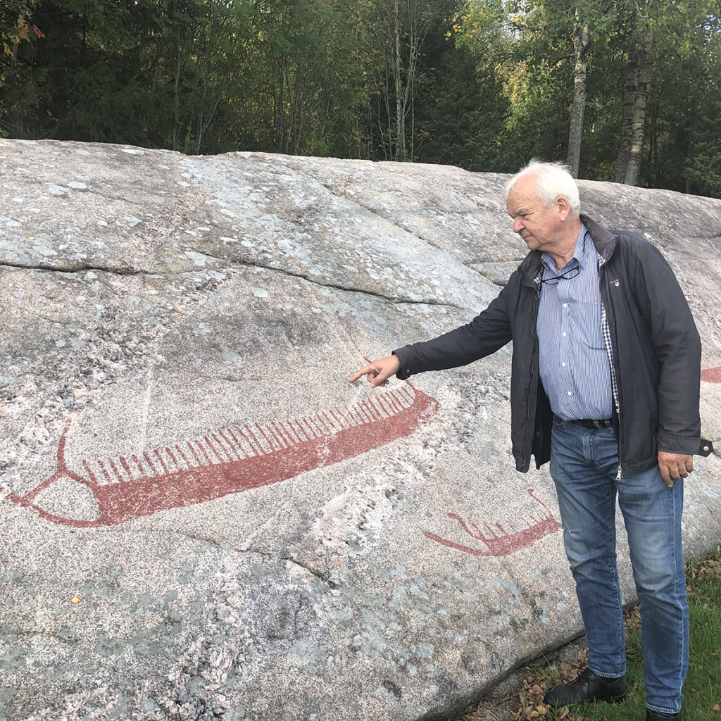 Board Vice Chair Knut Børge Knutsen at Oseberg Viking Heritage Foundation points out some enormous Bronze Age ship carvings. (Photo: Einar Chr. Erlingsen).
